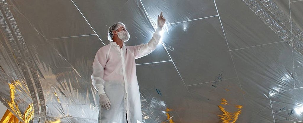 An engineer examines one of the sunshield's layers. 