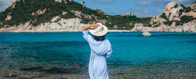 woman from behind, standing on a beach in Sardinia