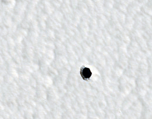 A round hole in a white surface