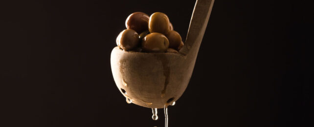 olives in dripping wooden spoon
