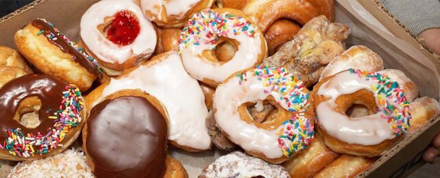 Street vendor carrying box of doughnuts, mid section, elevated view