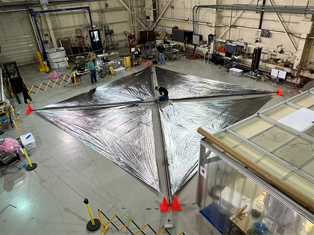 The 30 foot wide unfurled silver solar sail on the ground of the research center