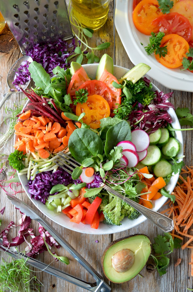 colorful salad bowl including raw veggies like carrots and radish 