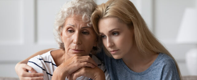 older woman being comforted by a younger woman