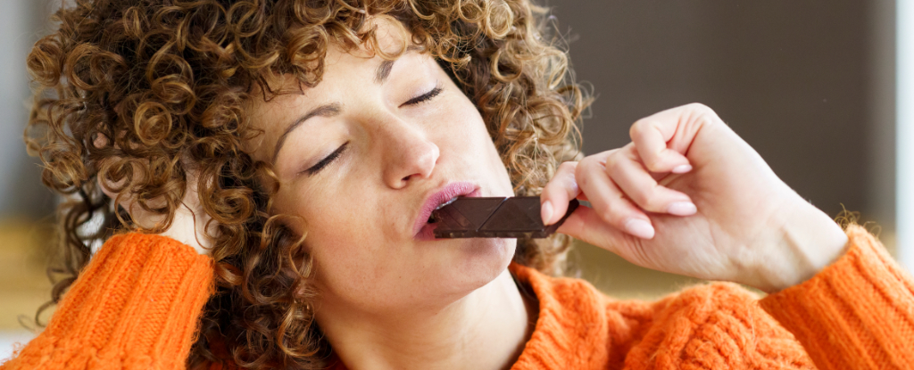 woman with curly hair eating chocolate