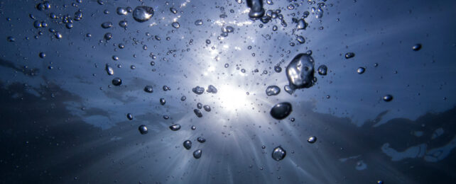 bubbles under water with sun filtering through