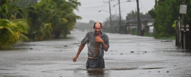 A man walking in hip deep flood waters