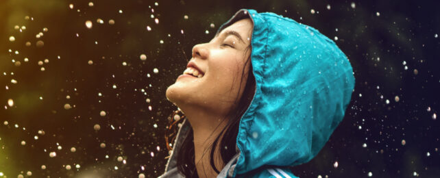 woman in a blue raincoat standing in the rain