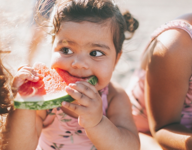 A child eating a slice of watermelon