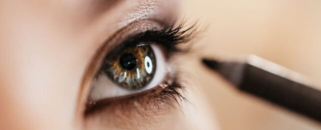 Close up of women applying eyeliner to haze eye