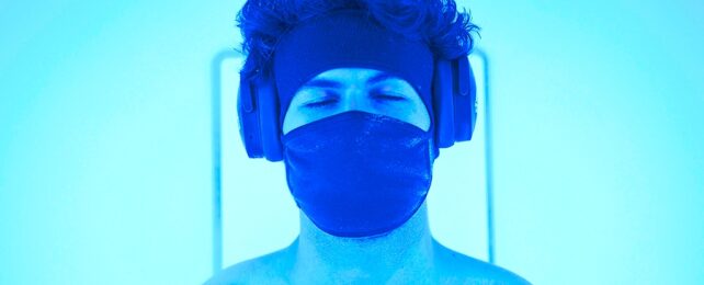 man sleeping with mask in blue room