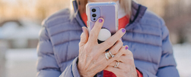 close-up of older woman's hands holding mobile phone