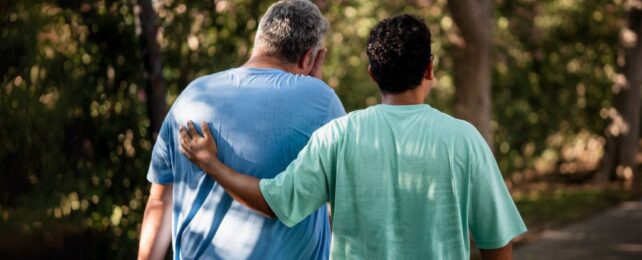 Larger and smaller men walking away from viewer