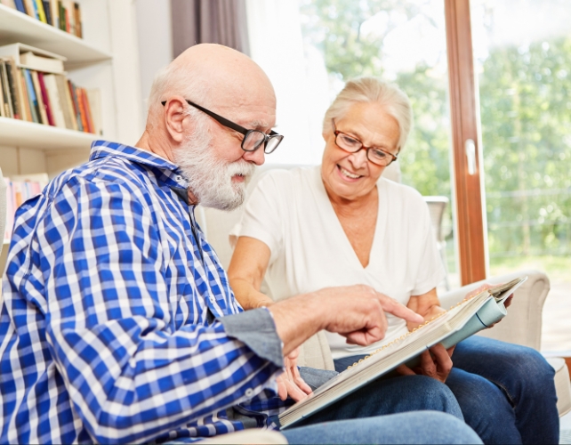 A senior man and woman looking at a book together