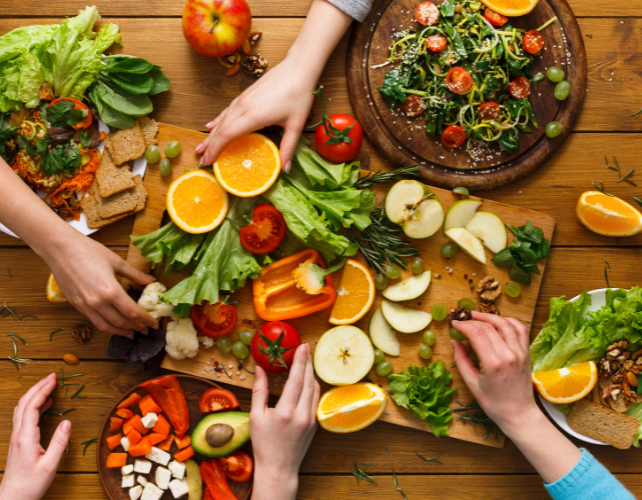 Food on a table with hands grabbing it