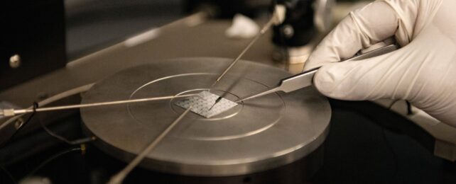 A gloved hand holding material on a burner