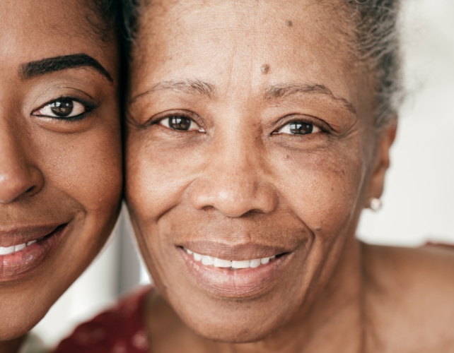 A young woman's face next to an older woman's face, both are smiling