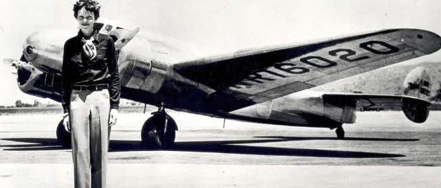 Amelia Earhart next to her lockheed electra plane