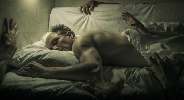 man in bed surrounded by hands