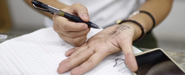 person writing on their hand