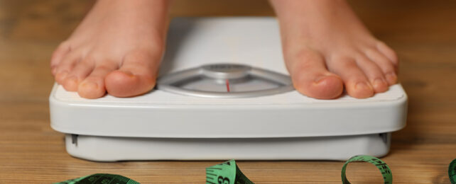 Someone weighing themselves on scales