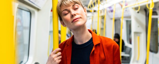 commuter with her eyes closed on a train