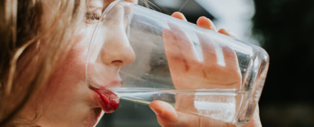 small girl drinking a glass of water