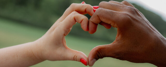 two hands making a love heart gesture