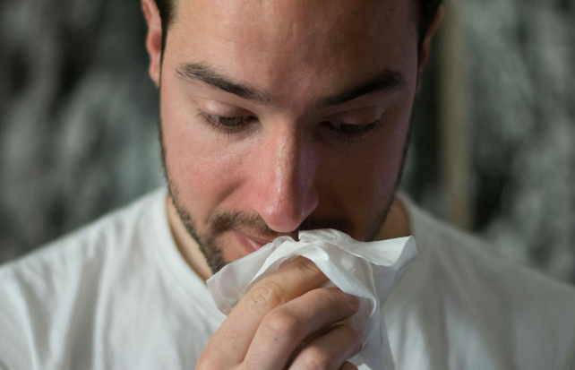 man blowing his nose