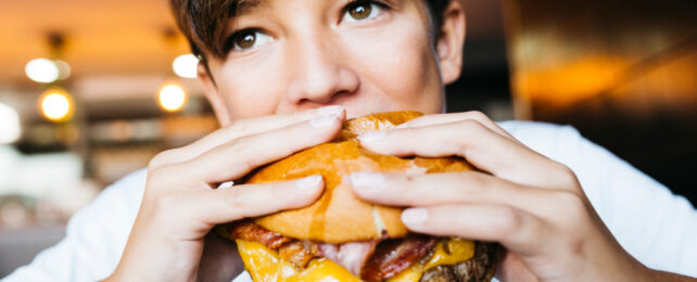 teenager eating a burger