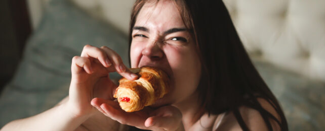 woman eating a pastry in bed