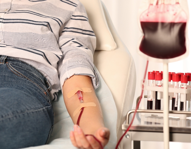 A person's arm with a cannula, receiving a blood transfusion