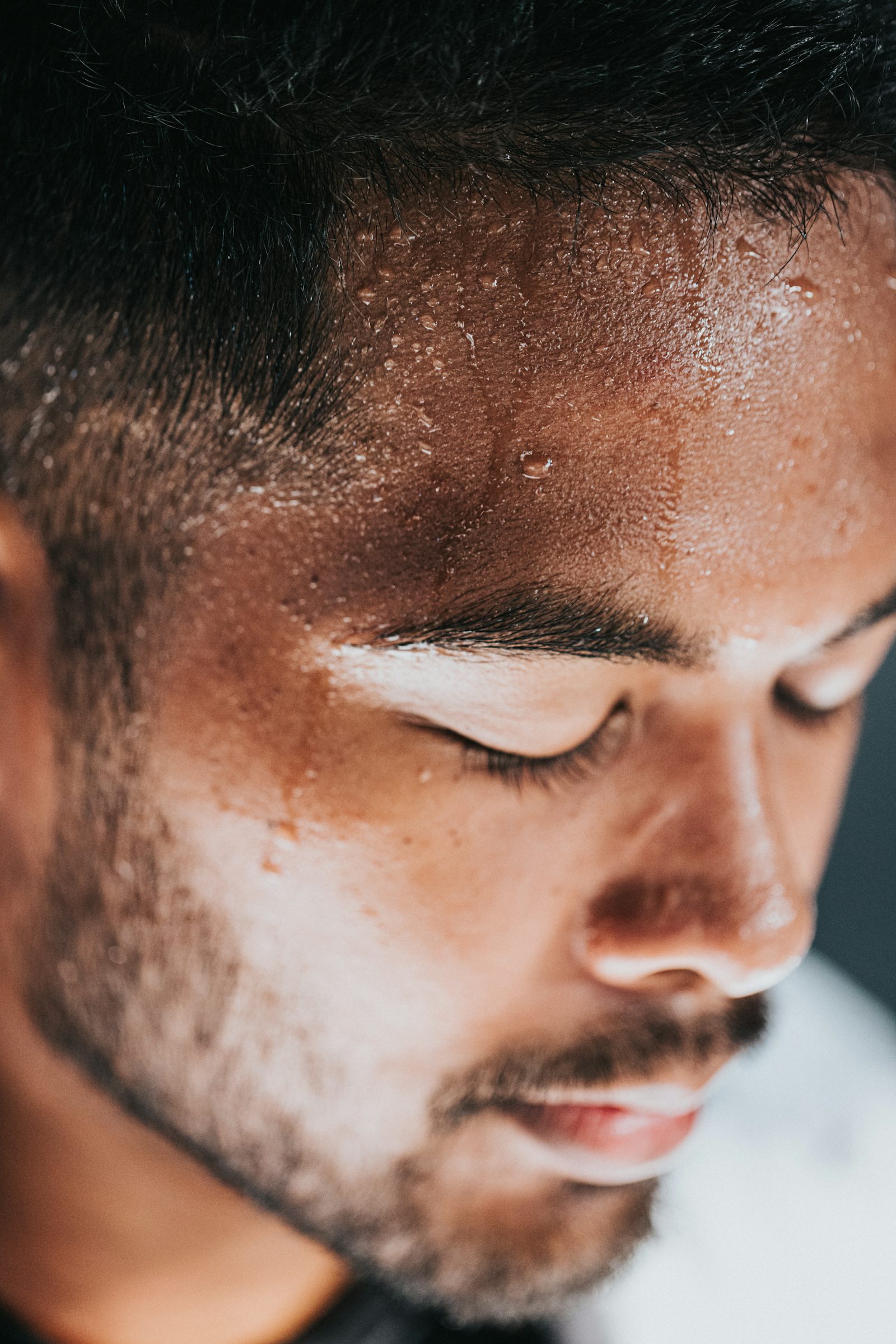 Close up of sweat dripping down man's forehead