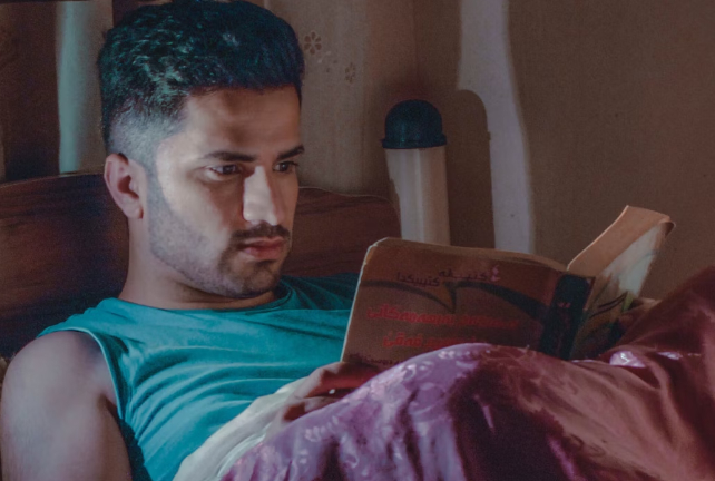 man reading a book while in bed