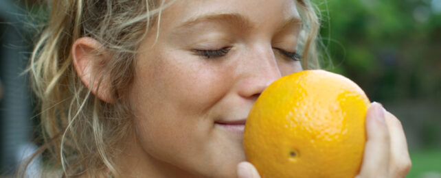 woman smelling an orange