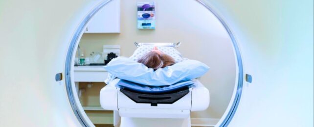 Woman lying on a bed in preparation for an MRI