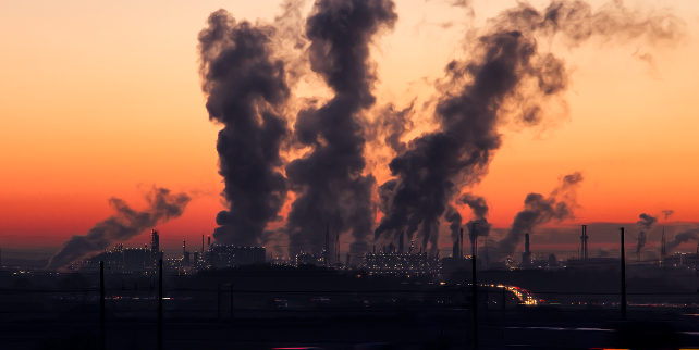 polluting smoke stacks at sunset