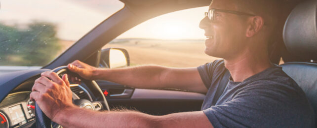 man driving at sunset