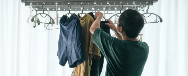 man hanging washing up inside