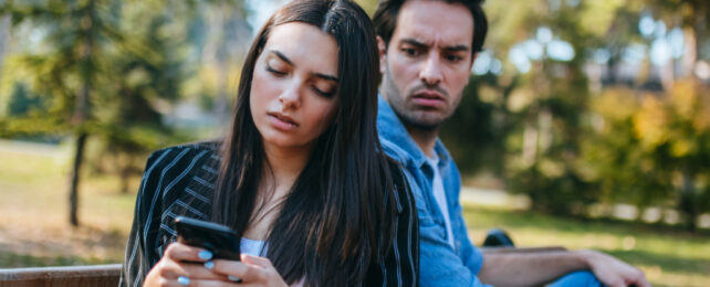 man looking at woman while she's texting