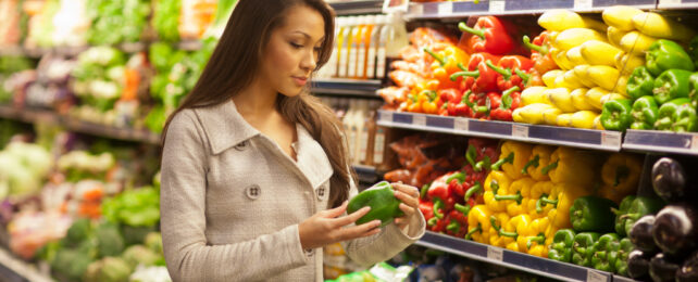 woman selecting from stand of vegetables