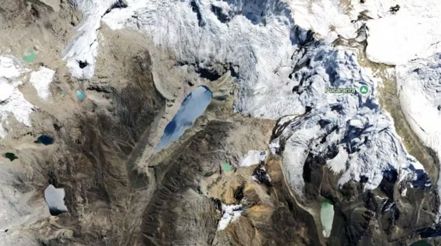 Aerial view of teardrop shaped lake in the Andes mountains surrounded by glaciers