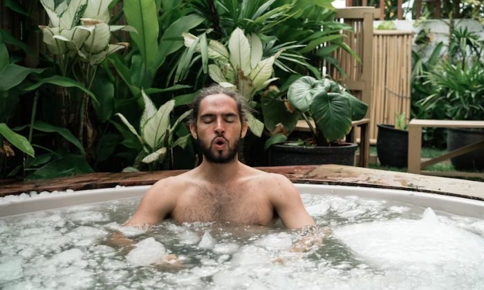 Cold looking man in large spa-like ice bath