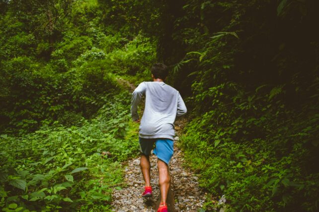 Man jogging in forest in sweaty clothes