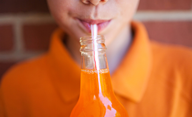 boy drinking orange soda