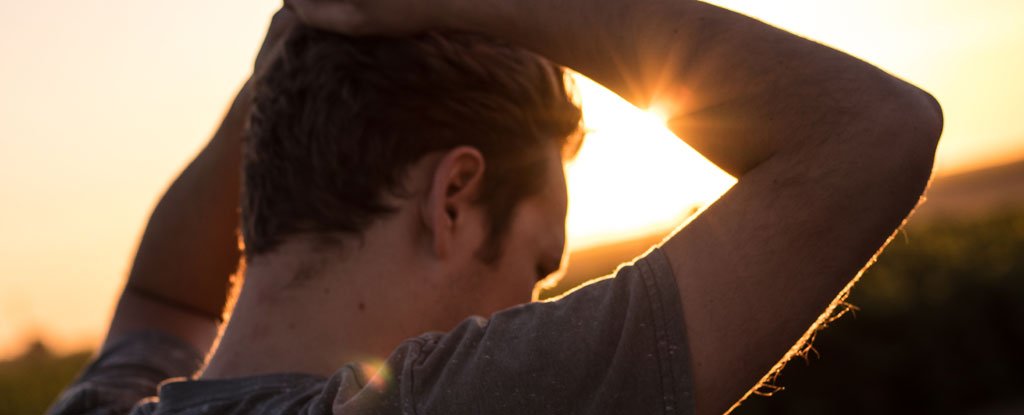 Person with hands over head in sunlight